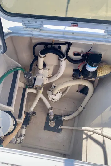 Tranquility Base Yacht Photos Pics Engine compartment of a 2003 PDQ-34 boat, showing hoses and mechanical components.