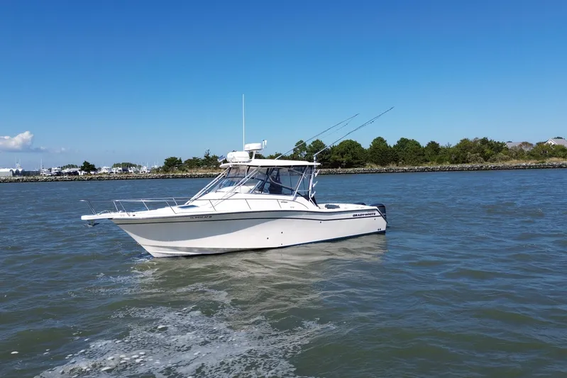 Get Bent Yacht Photos Pics 2005 Grady-White Express 330 boat cruising on a sunny day near the shoreline.