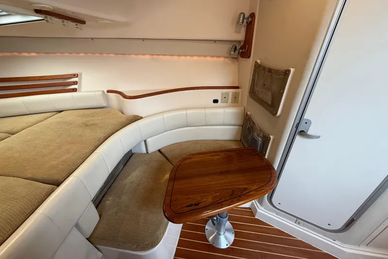 Get Bent Yacht Photos Pics 2005 Grady-White Express 330 cabin interior with cushioned seating and wooden table.