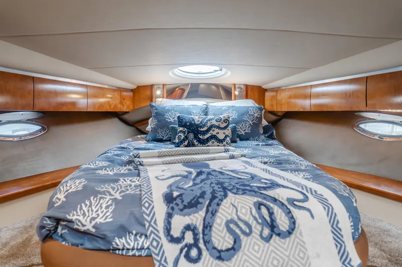 Eurybia Yacht Photos Pics Luxurious cabin interior of 2006 Cruisers Yachts 420 Express with nautical-themed bedding.