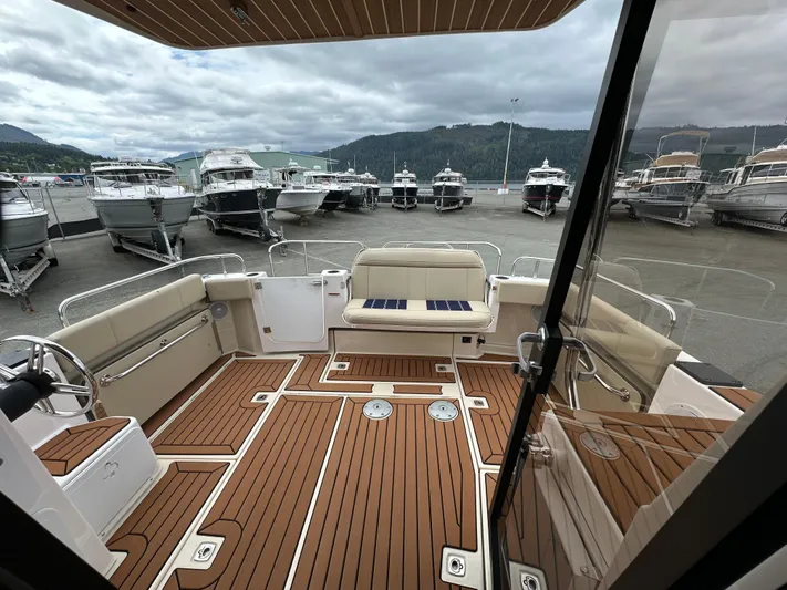  Yacht Photos Pics 2025 Ranger Tugs R29 S boat interior with teak flooring, docked among other boats.