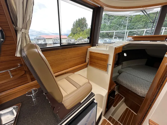  Yacht Photos Pics Interior of 2025 Ranger Tugs R29 S, featuring helm seat and cozy cabin area.