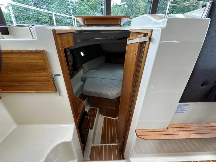  Yacht Photos Pics 2025 Ranger Tugs R29 S interior cabin with wooden finishes and cozy sleeping area.