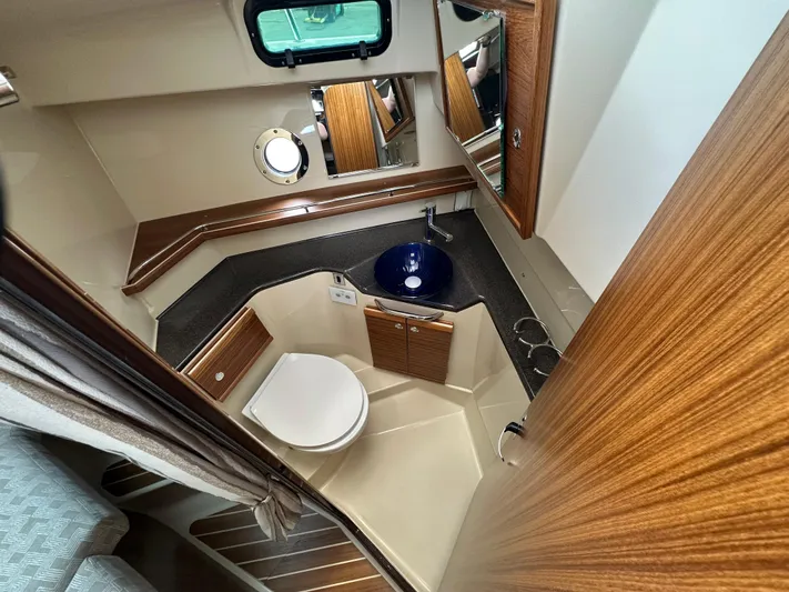  Yacht Photos Pics 2025 Ranger Tugs R29 S bathroom with modern sink, toilet, and wood accents.