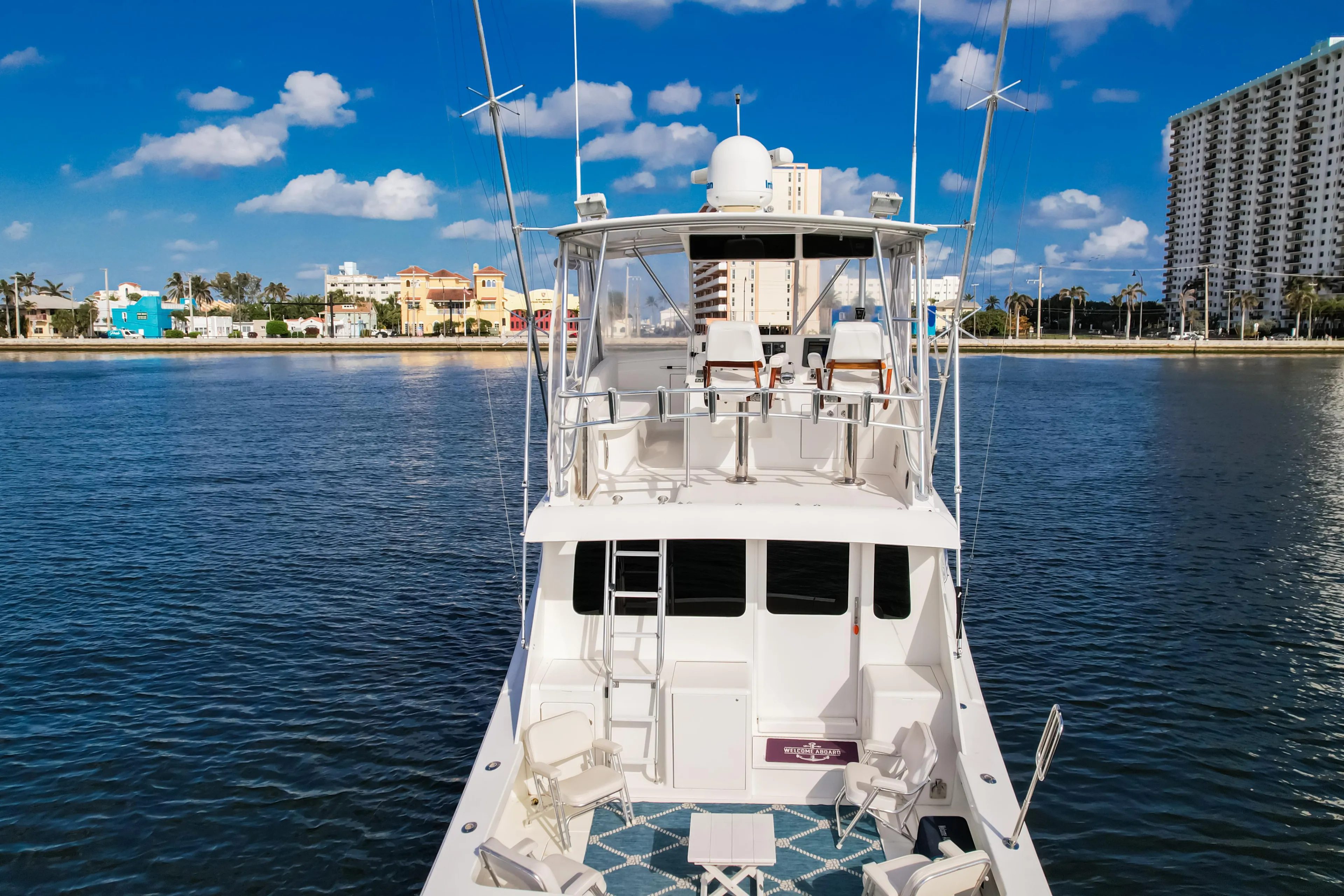 Luxury yacht on calm water with city skyline, Post 42 model, 2008.