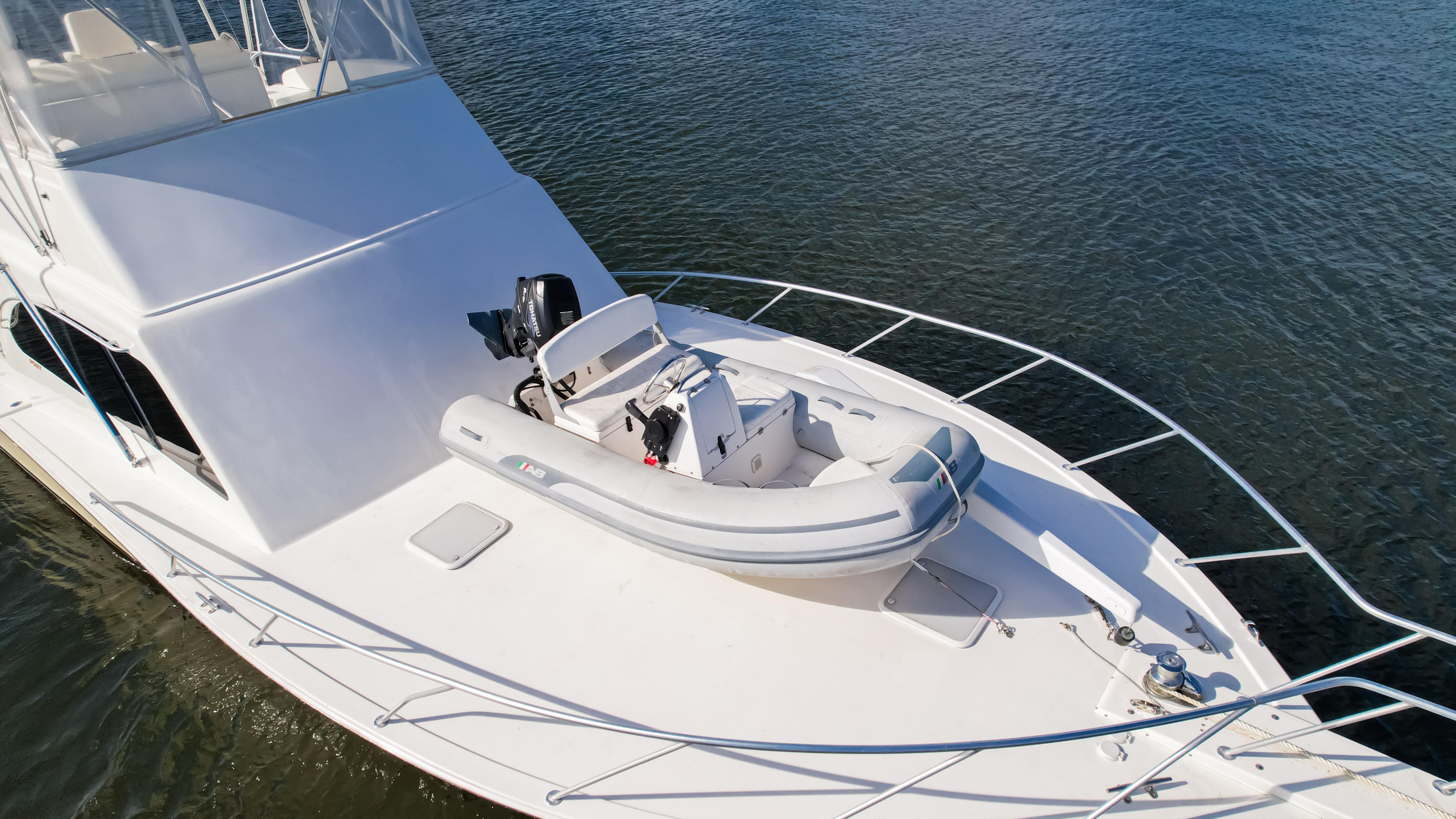 Luxury yacht Post 42 (2008) with inflatable boat on deck, cruising on calm waters.