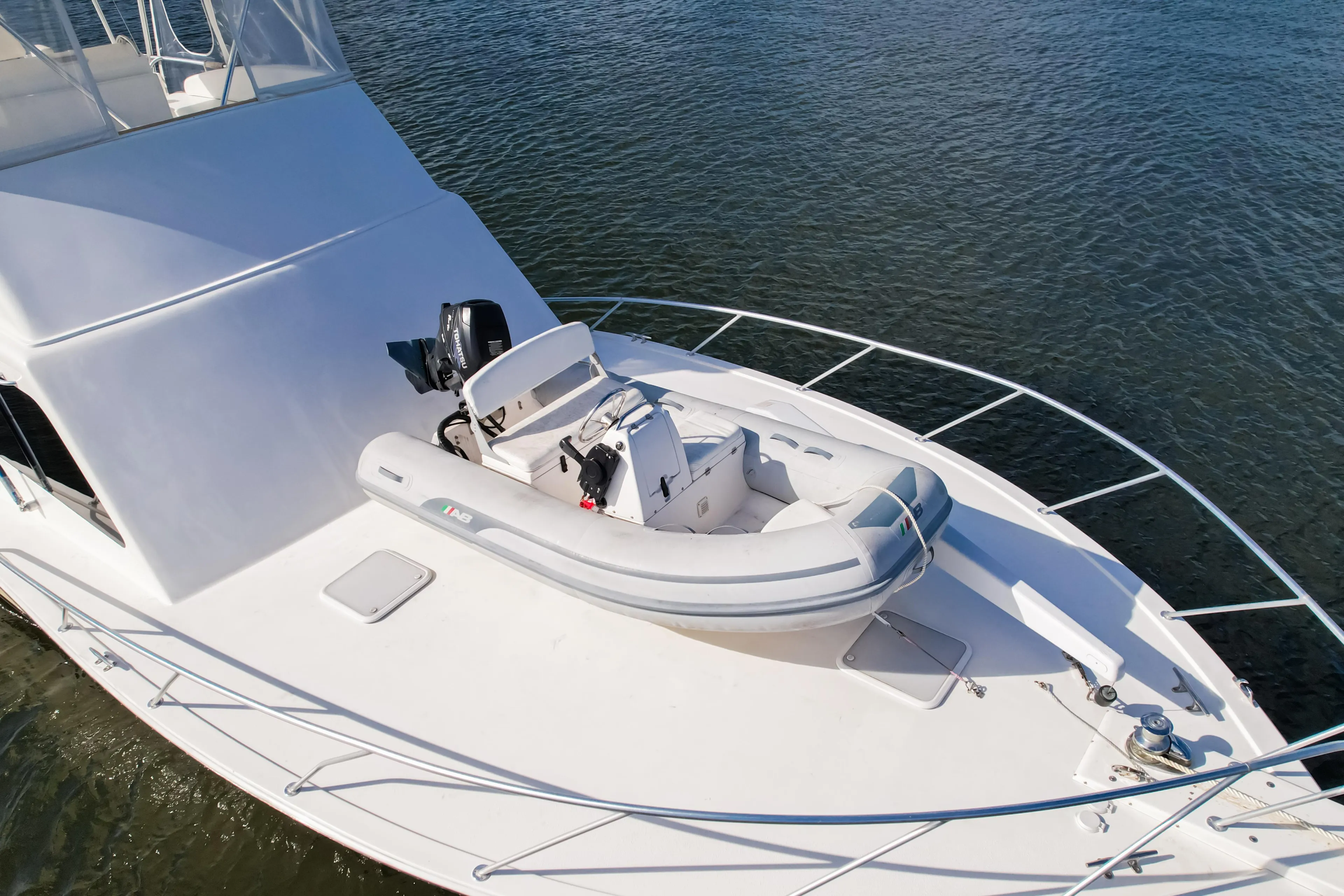 Luxury yacht Post 42 (2008) with inflatable boat on deck, cruising on calm waters.