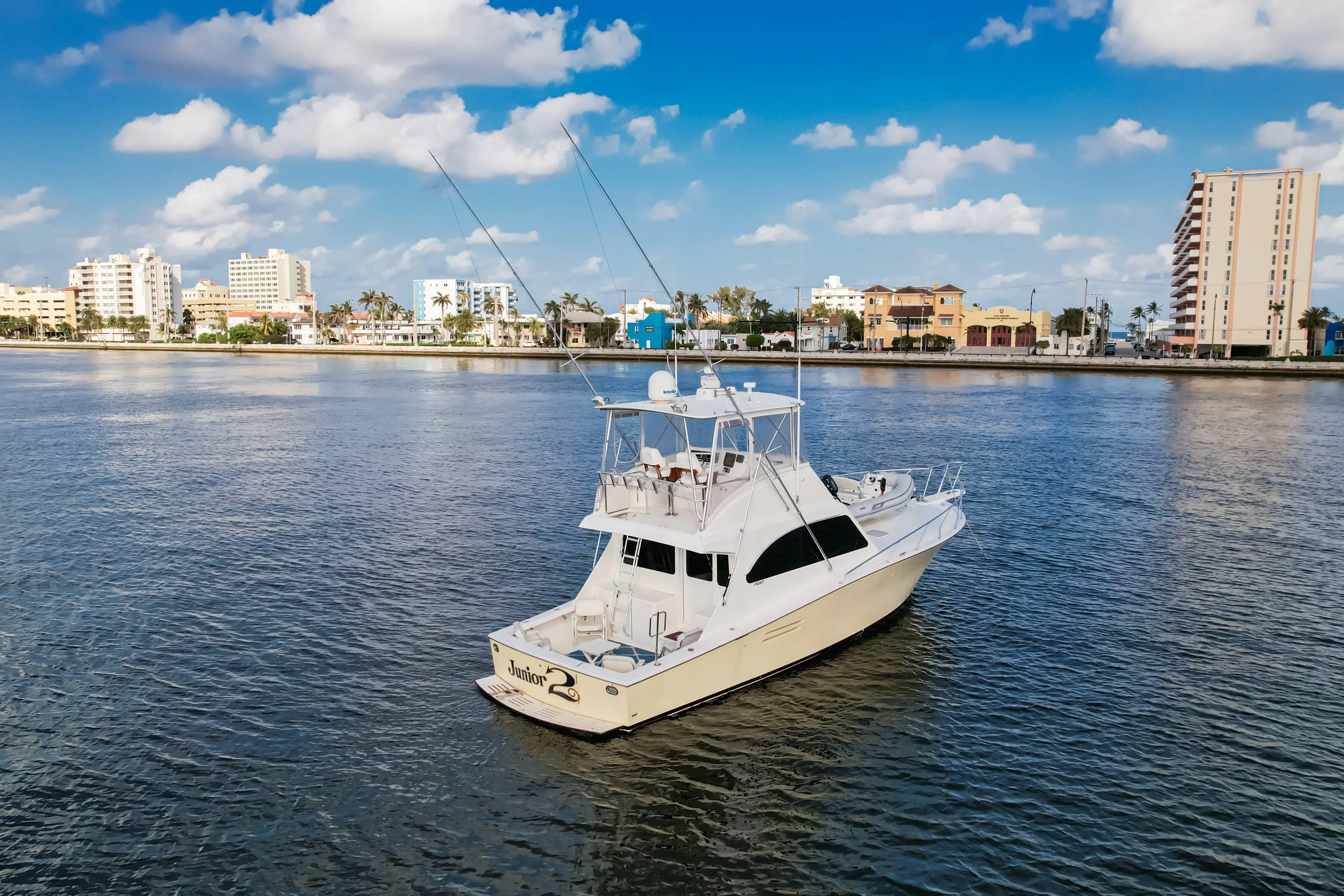 A 2008 Post 42 yacht on calm waters with a cityscape background under a blue sky.