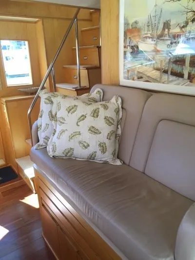 Whale's Way Yacht Photos Pics Interior of 1998 Hatteras 74 Sport Deck yacht with beige sofa and decorative pillows.