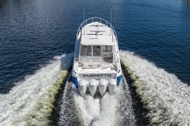  Yacht Photos Pics 2020 Intrepid 477 Evolution boat cruising on water, rear view.