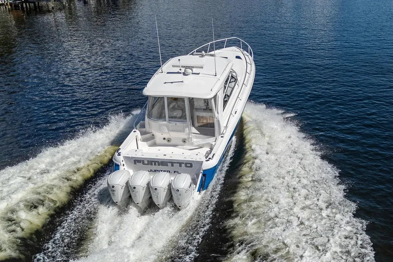  Yacht Photos Pics 2020 Intrepid 477 Evolution boat cruising on water with four outboard engines.