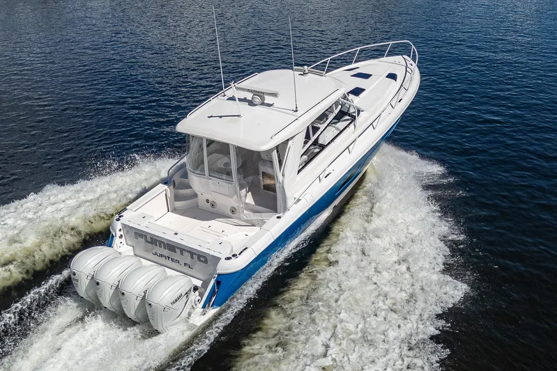  Yacht Photos Pics 2020 Intrepid 477 Evolution boat cruising on water with four outboard engines.