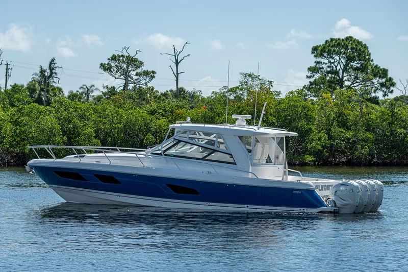  Yacht Photos Pics 2020 Intrepid 477 Evolution boat on calm water with lush green background.