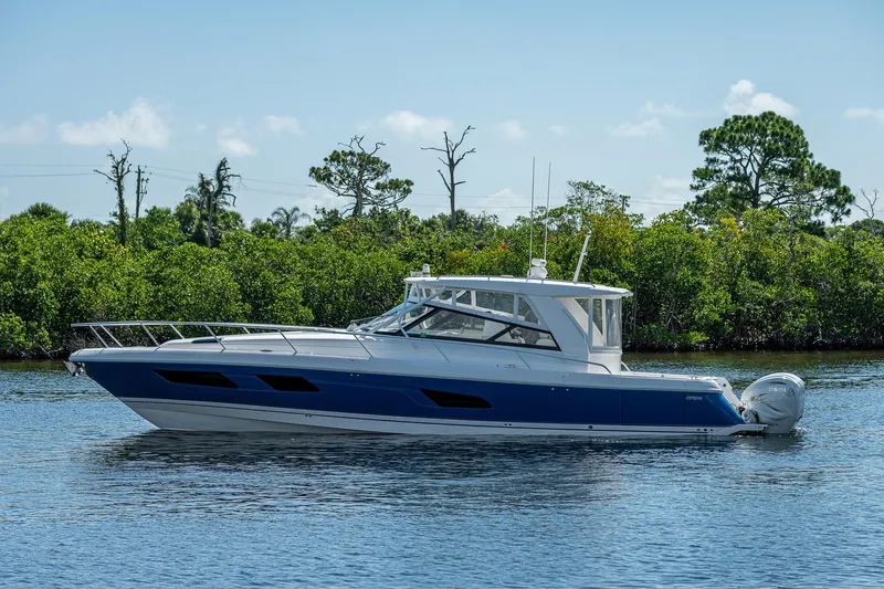  Yacht Photos Pics 2020 Intrepid 477 Evolution boat on calm water with lush greenery background.