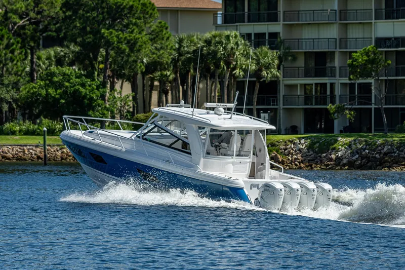  Yacht Photos Pics 2020 Intrepid 477 Evolution boat cruising on water near shoreline.