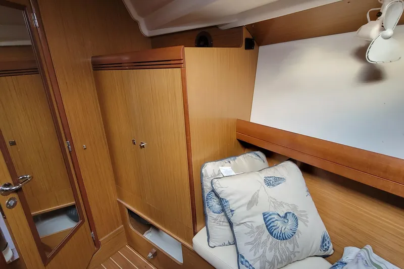  Yacht Photos Pics Interior cabin of 2008 Jeanneau Sun Odyssey 42 DS with wooden finish and decorative pillows.