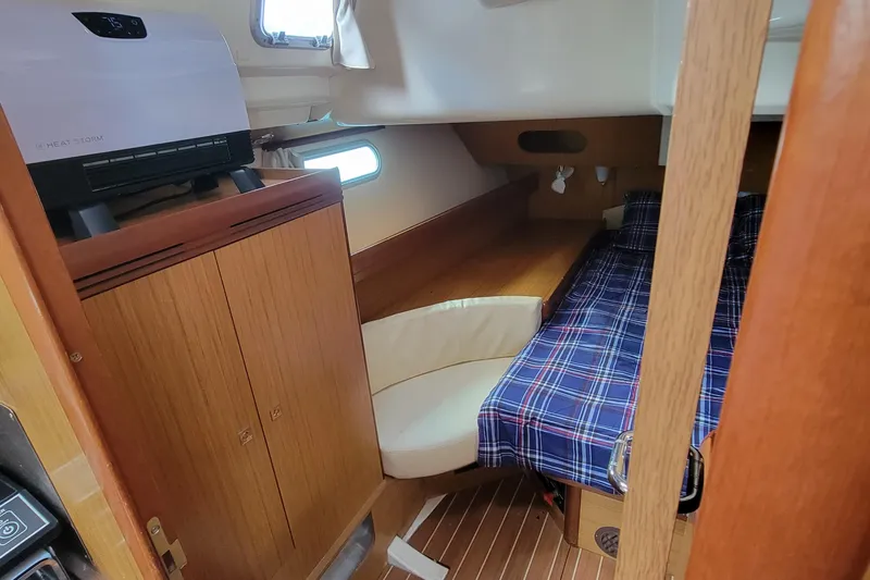  Yacht Photos Pics Interior cabin of 2008 Jeanneau Sun Odyssey 42 DS with plaid bedding and wood finish.
