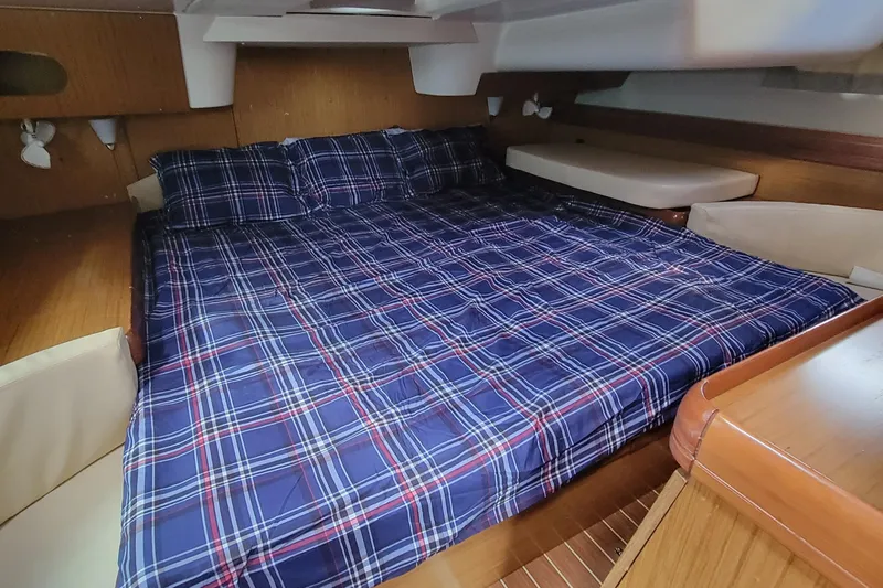  Yacht Photos Pics Cozy cabin interior of 2008 Jeanneau Sun Odyssey 42 DS with plaid bedding.