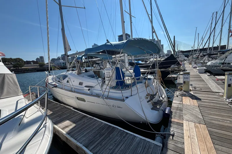  Yacht Photos Pics 2008 Jeanneau Sun Odyssey 42 DS sailboat docked at marina, clear sky, cityscape background.