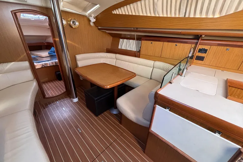  Yacht Photos Pics Interior of 2008 Jeanneau Sun Odyssey 42 DS yacht with wood finish and seating area.