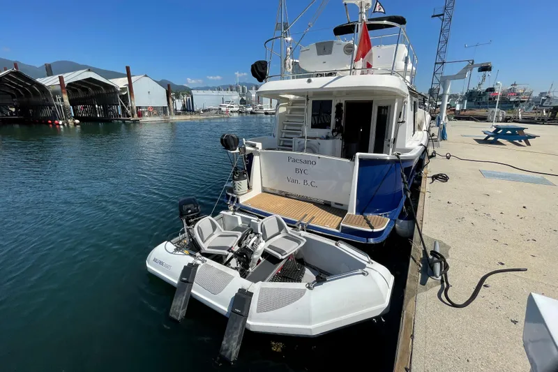  Yacht Photos Pics 2007 Fathom Yachts 40 docked with a small boat, sunny marina setting.