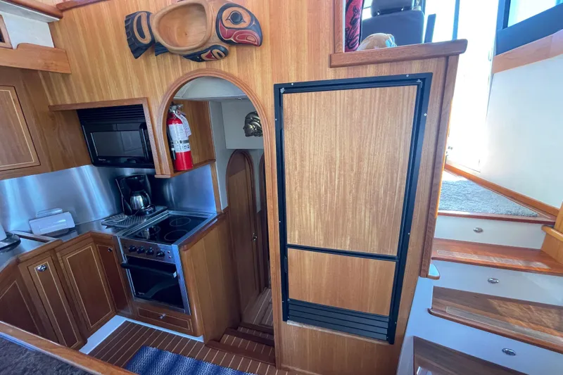  Yacht Photos Pics Interior of 2007 Fathom Yachts 40, featuring a compact kitchen with wooden cabinetry.