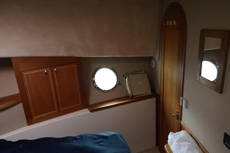  Yacht Photos Pics Cozy cabin interior of 2007 Fathom Yachts 40 with wooden accents and porthole window.