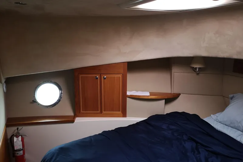  Yacht Photos Pics Cozy cabin interior of 2007 Fathom Yachts 40 with porthole and wooden cabinetry.