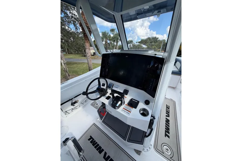  Yacht Photos Pics 2025 Twin Vee 260 GFX2 CC boat console with steering wheel and navigation display.