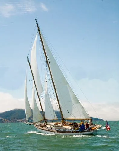 1927 Schock Staysail Schooner sailing on open water under clear blue skies.