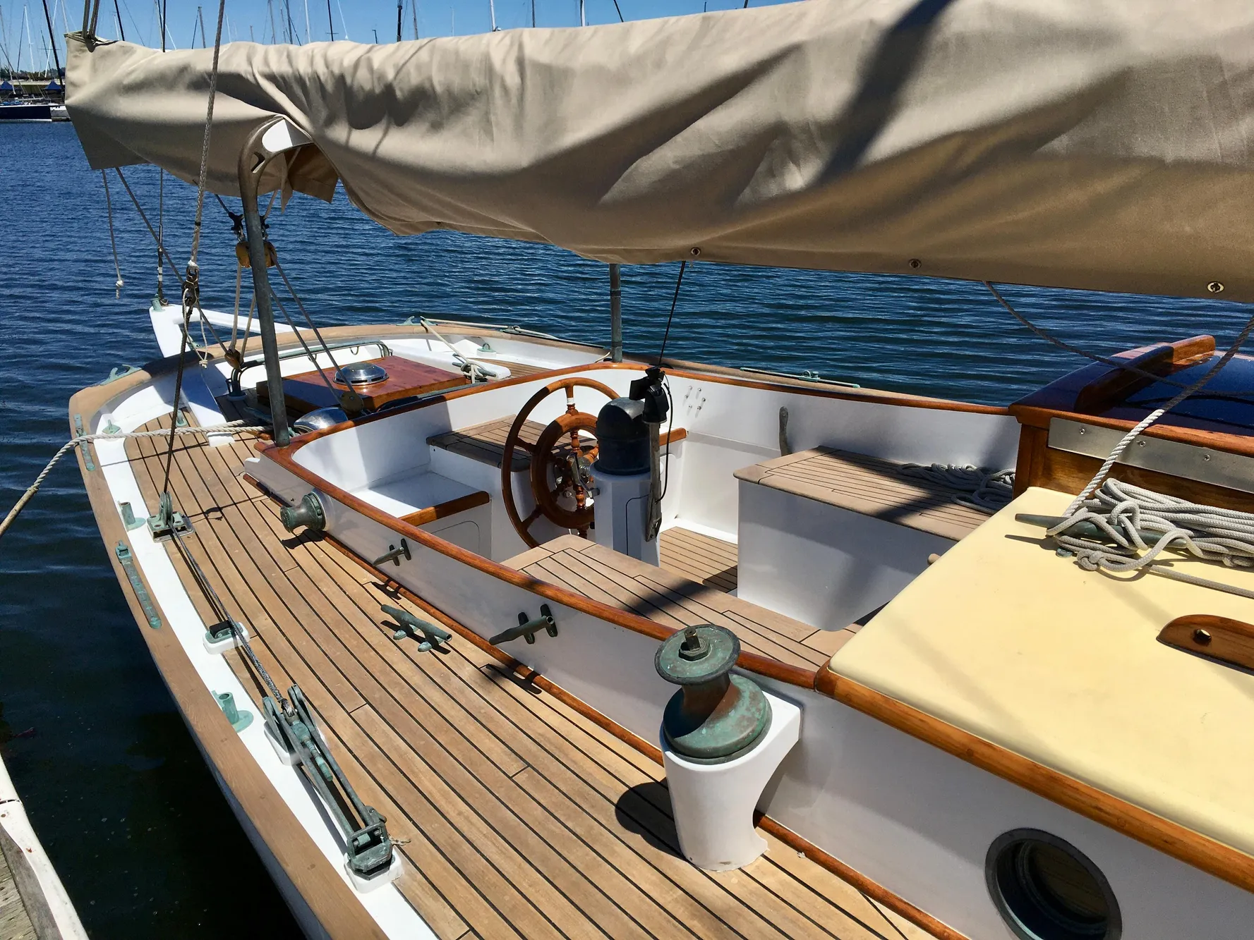 1927 Schock Staysail Schooner with wooden deck and covered sails docked at marina.