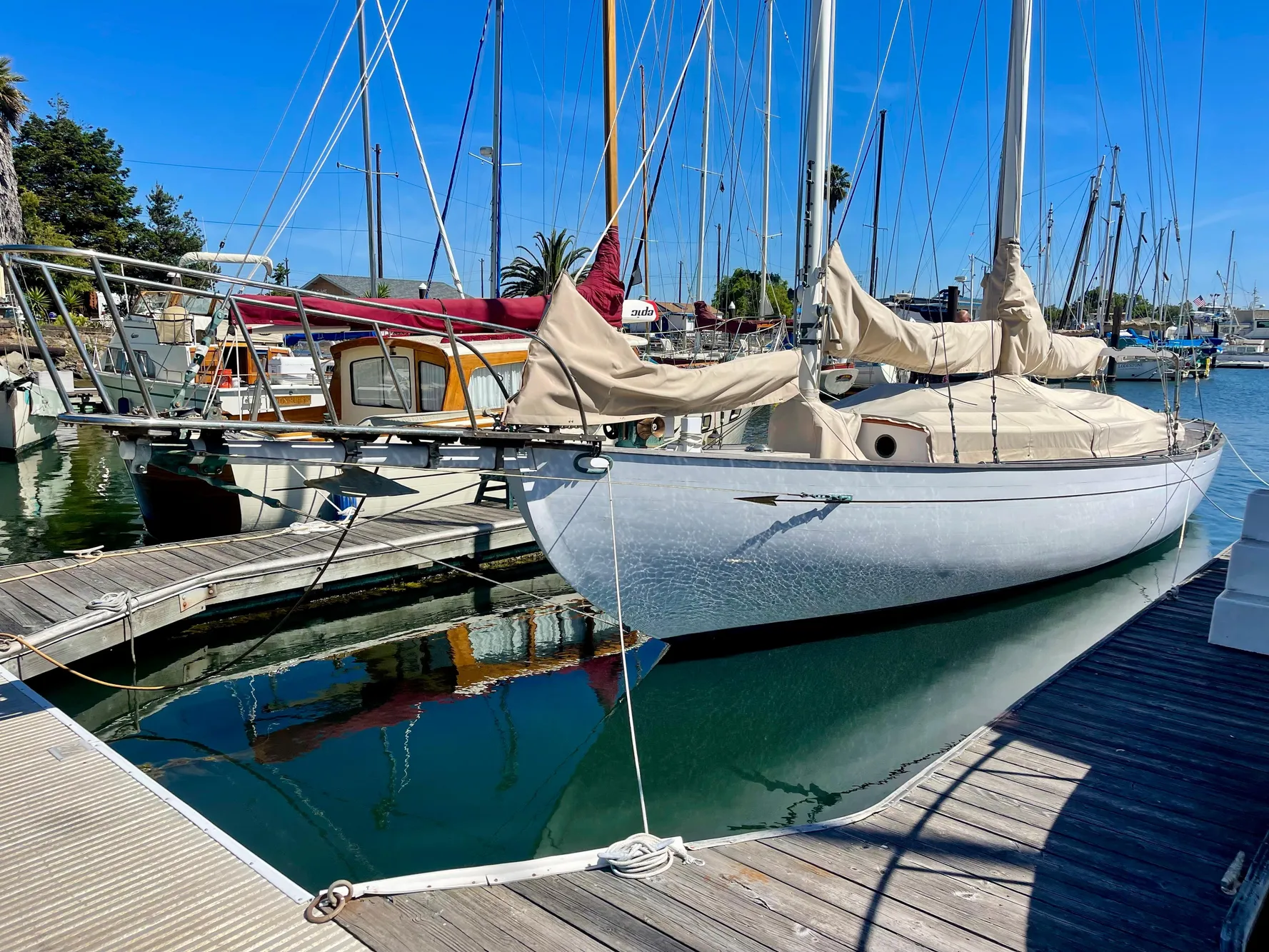 1927 Schock Staysail Schooner docked at a marina, reflecting on calm water.
