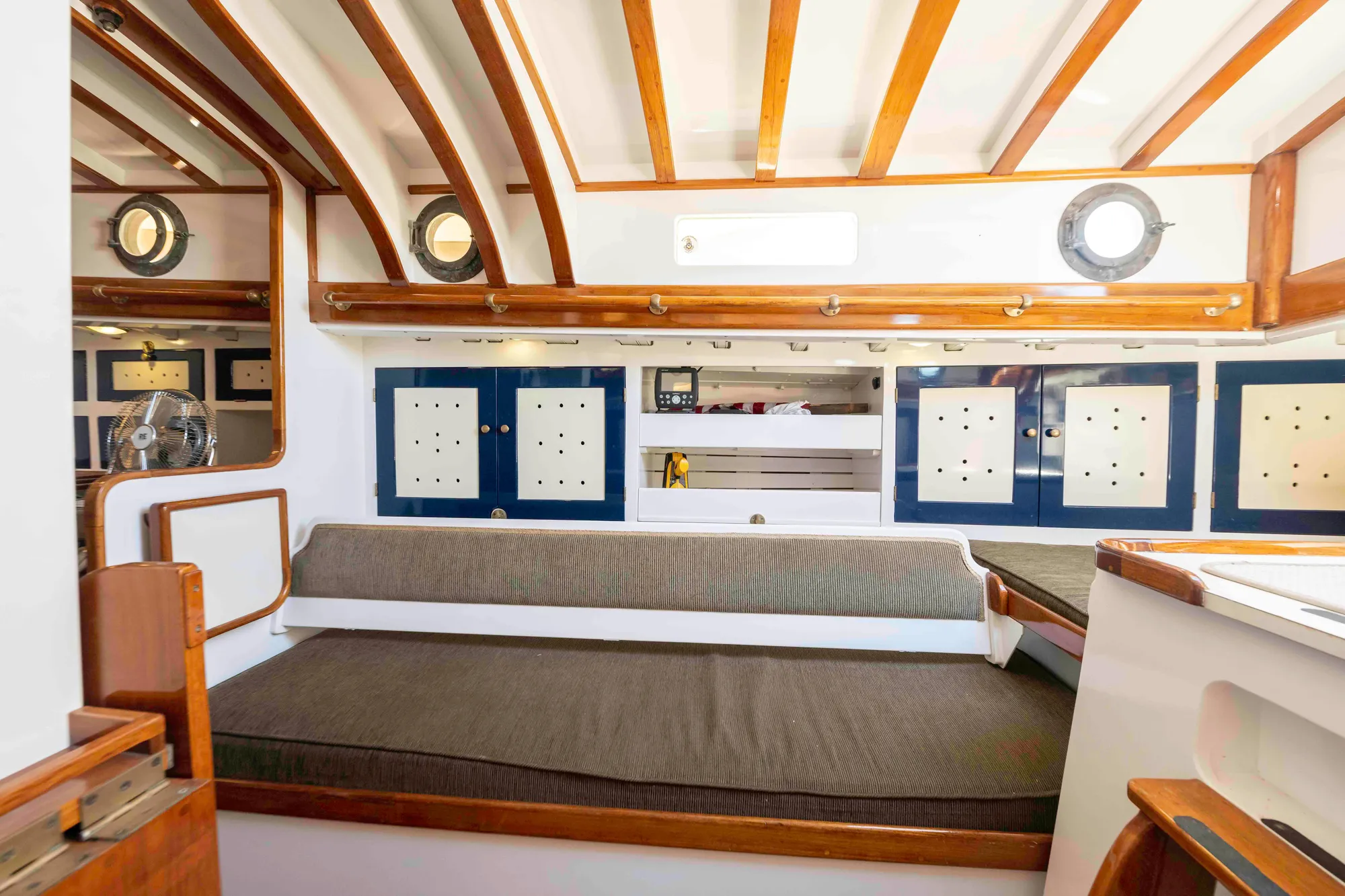 Interior of 1927 Schock Staysail Schooner with wooden beams and cozy seating.