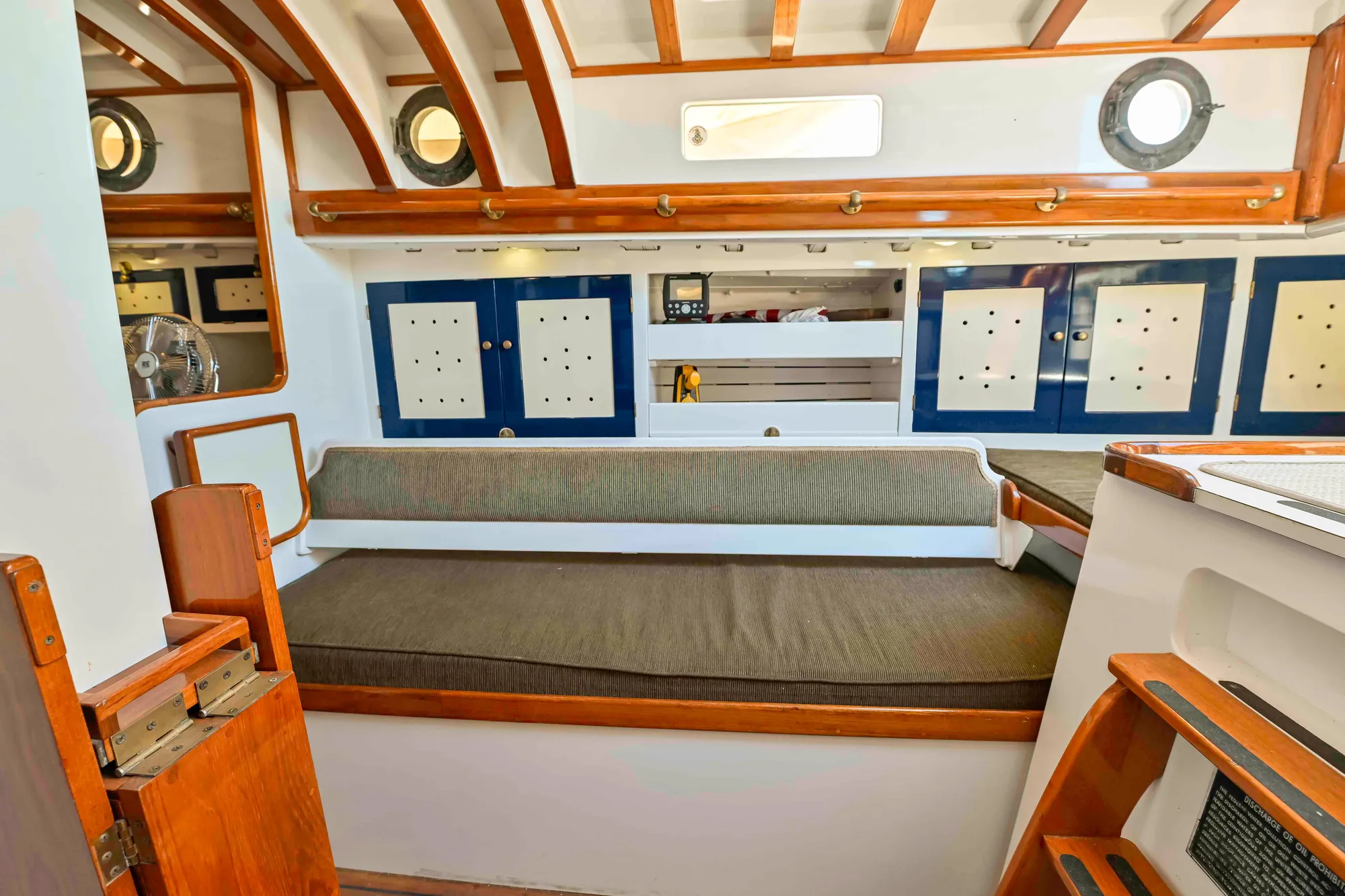 1927 Schock Staysail Schooner interior with wooden accents and cozy seating area.