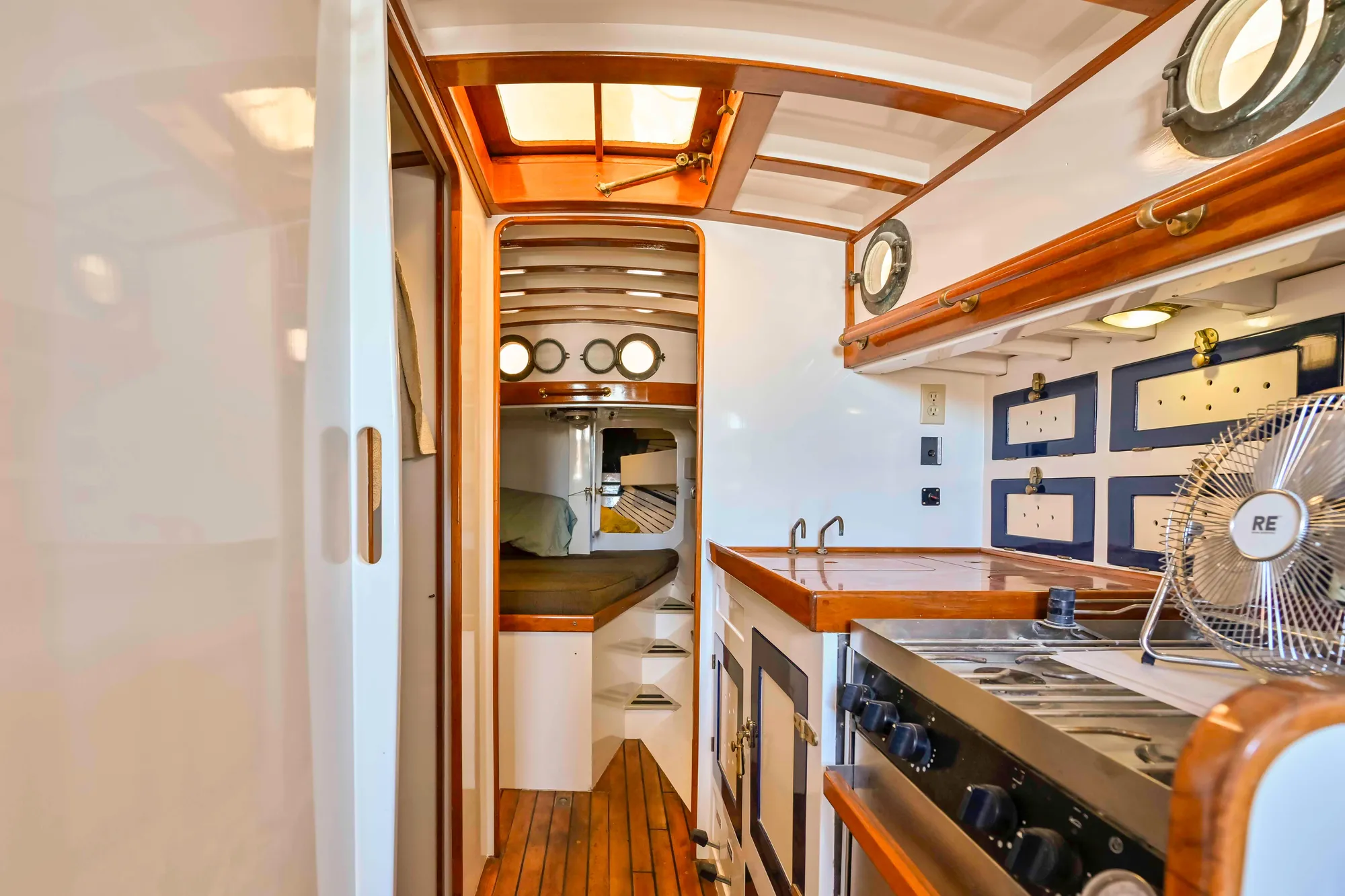 Interior of a 1927 Schock Staysail Schooner with wooden finishes and nautical decor.