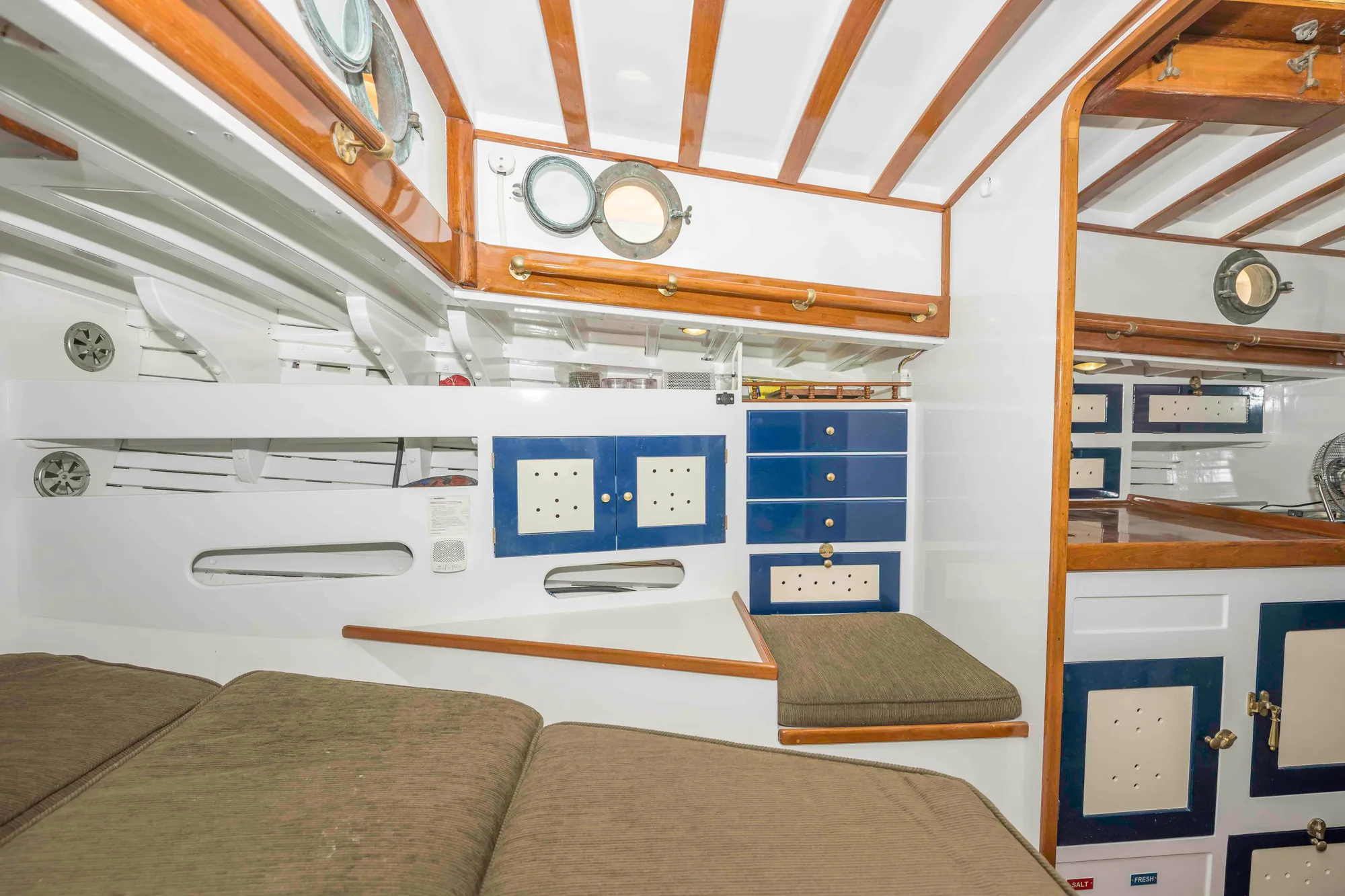 Interior of a 1927 Schock Staysail Schooner with wooden beams and nautical decor.