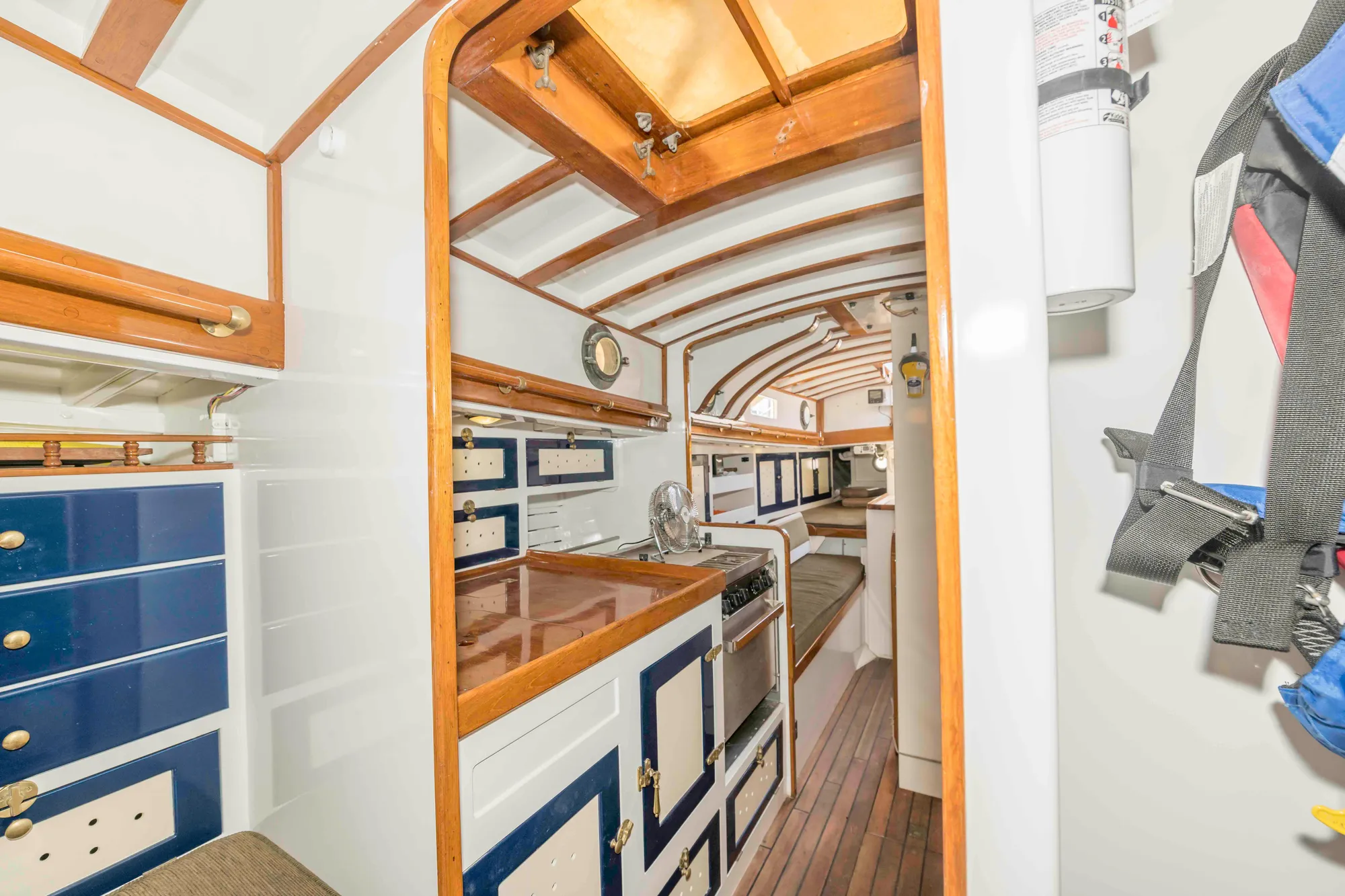 Interior of a 1927 Schock Staysail Schooner with wooden cabinetry and nautical decor.