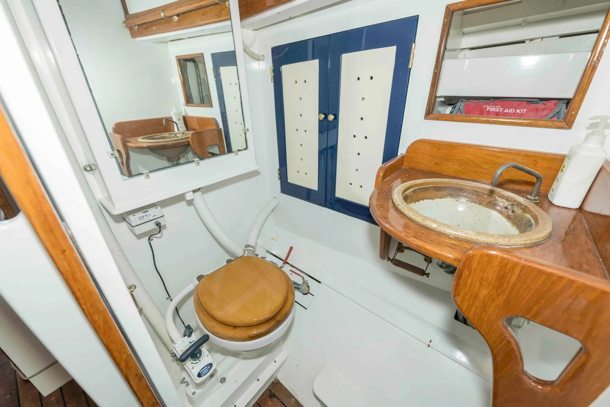 Bathroom interior of 1927 Schock Staysail Schooner with wooden accents and nautical fixtures.