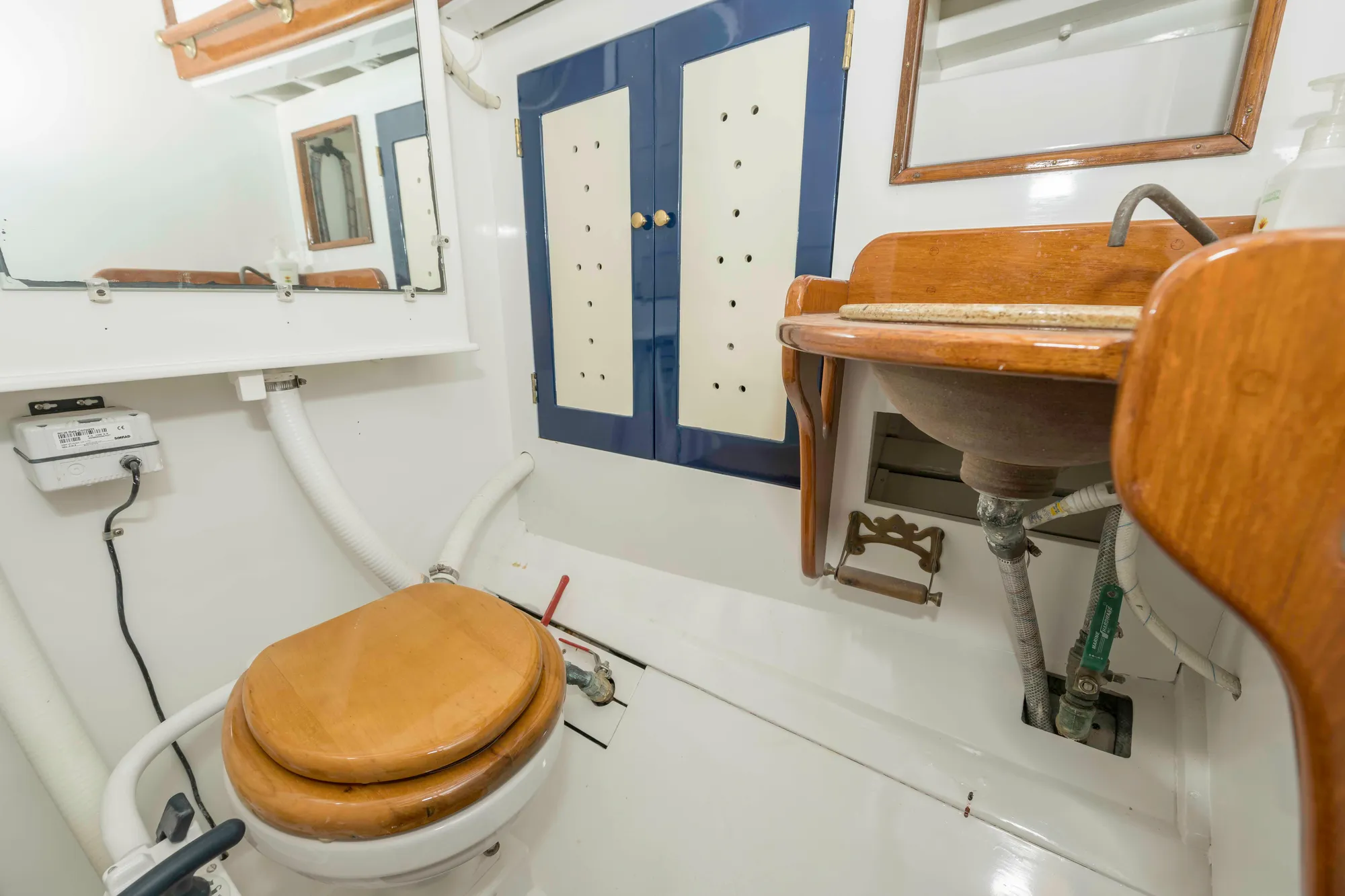 Bathroom interior of 1927 Schock Staysail Schooner with wooden accents and nautical design.