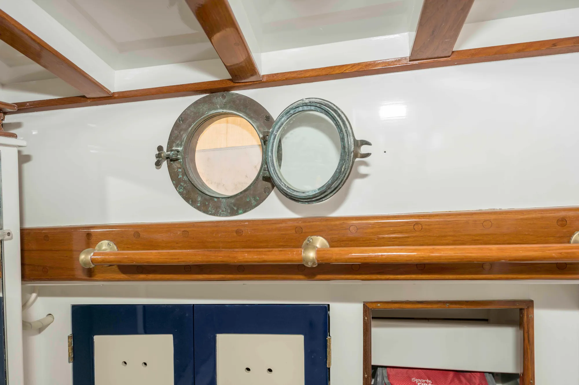 Interior of 1927 Schock Staysail Schooner with porthole and wooden accents.