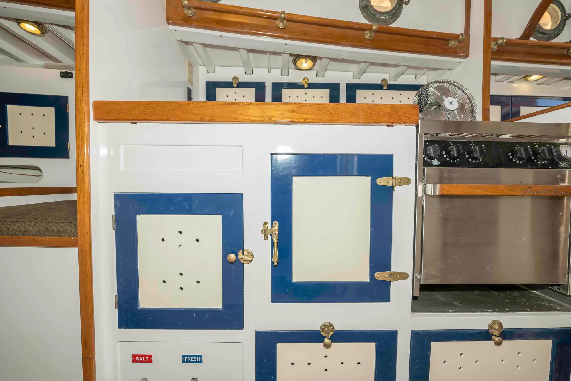 Interior of 1927 Schock Staysail Schooner with vintage cabinetry and stove.