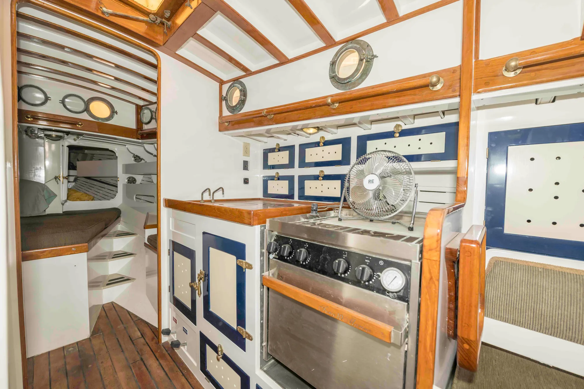 Interior of a 1927 Schock Staysail Schooner with wooden cabinetry and nautical decor.