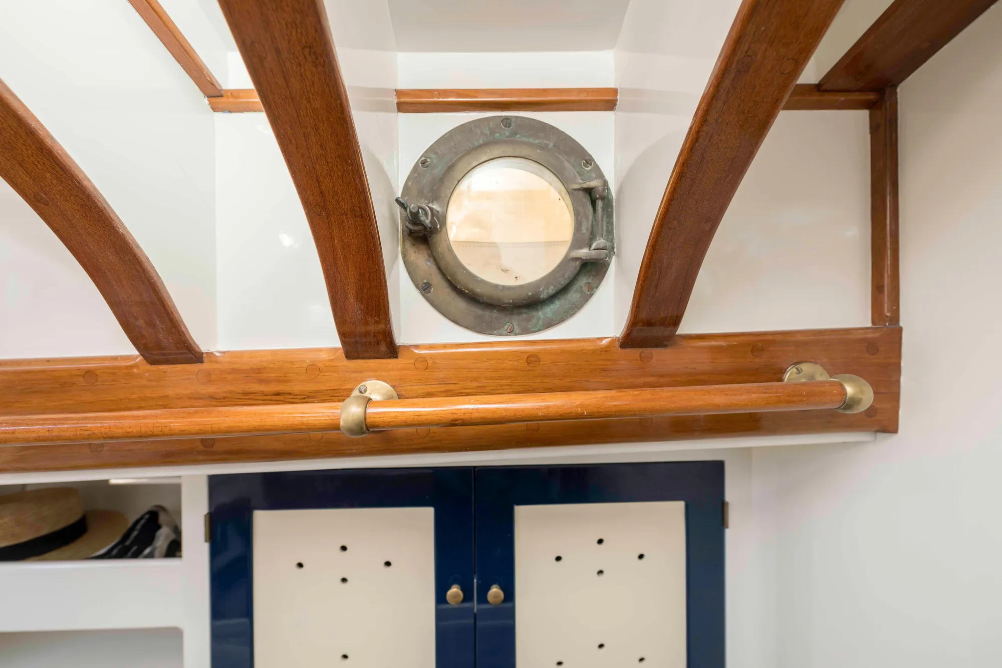 Interior of 1927 Schock Staysail Schooner with wooden beams and porthole window.