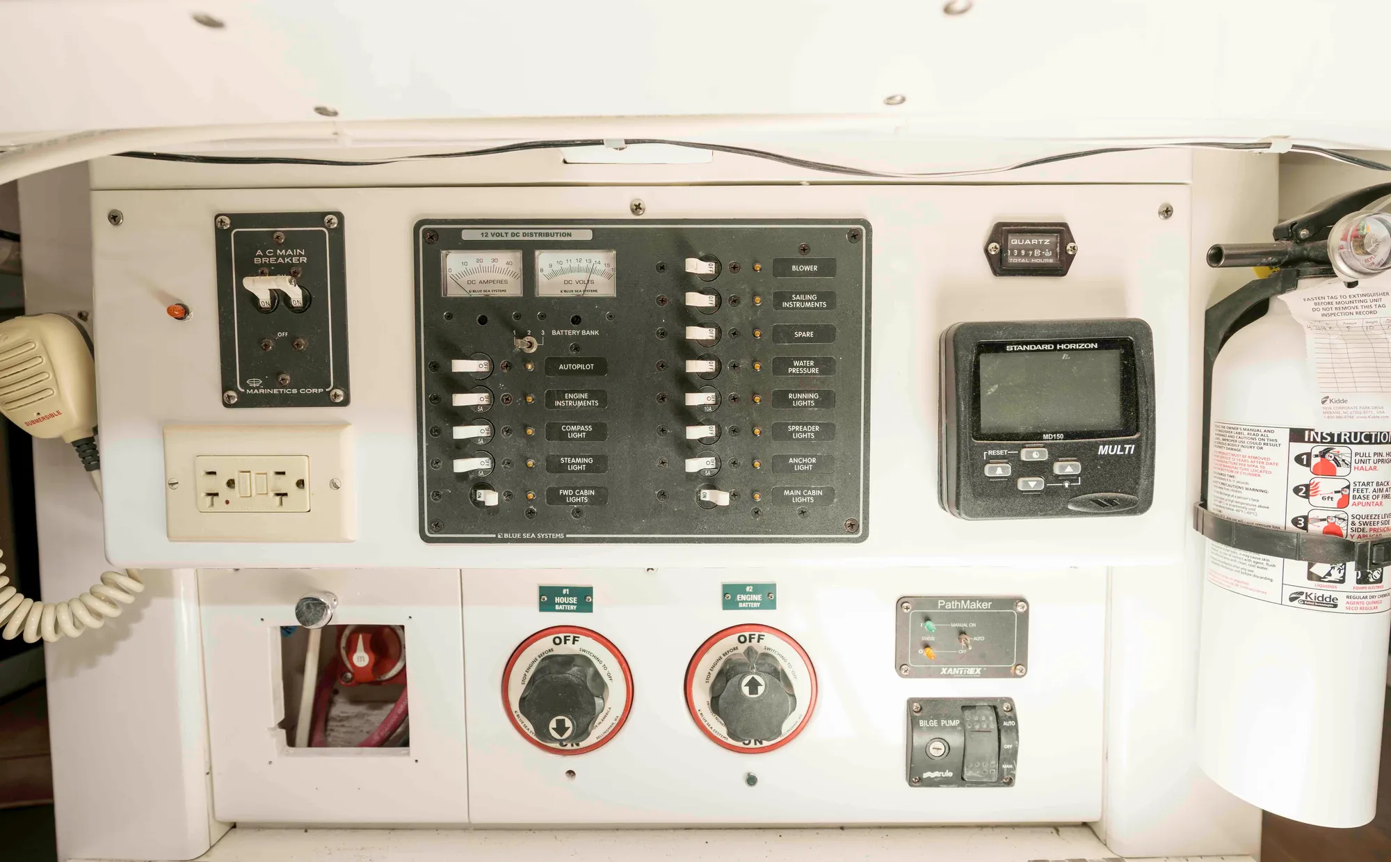 Electrical control panel on a 1927 Schock Staysail Schooner, featuring switches and a fire extinguisher.