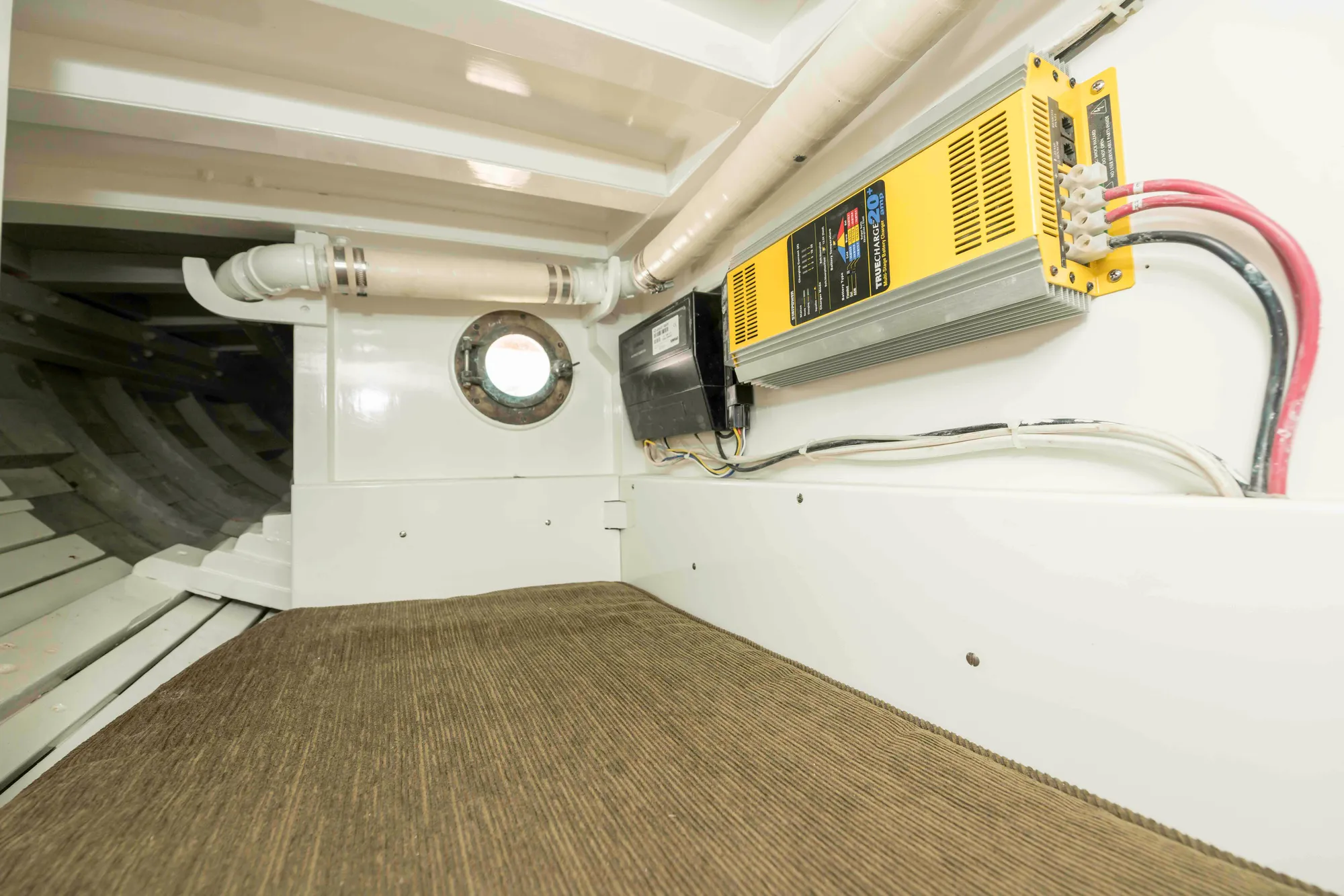 Interior of 1927 Schock Staysail Schooner with electrical equipment and porthole.
