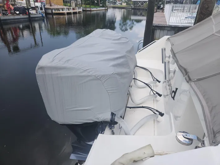  Yacht Photos Pics Covered outboard motor on a 2015 Jupiter 41 SB boat docked by a calm waterfront.