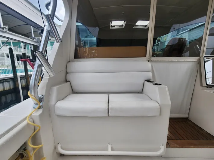  Yacht Photos Pics White seating area on a 2015 Jupiter 41 SB boat, docked at a marina.