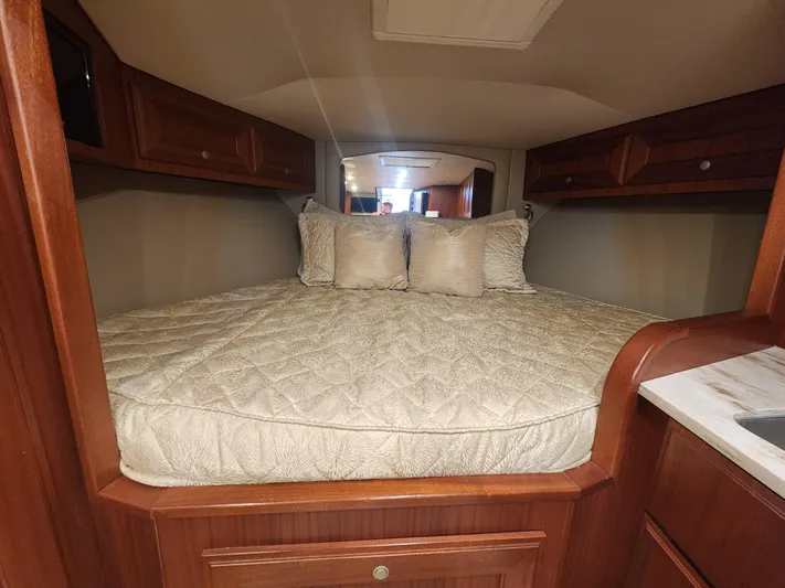  Yacht Photos Pics Cozy cabin interior of 2015 Jupiter 41 SB with plush bedding and wooden cabinetry.