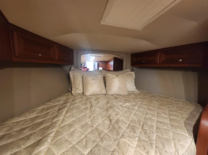  Yacht Photos Pics Cozy cabin bedroom in 2015 Jupiter 41 SB boat with quilted bedding and wooden cabinets.