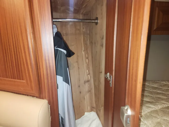  Yacht Photos Pics Wooden closet interior with hanging clothes in a 2015 Jupiter 41 SB boat.